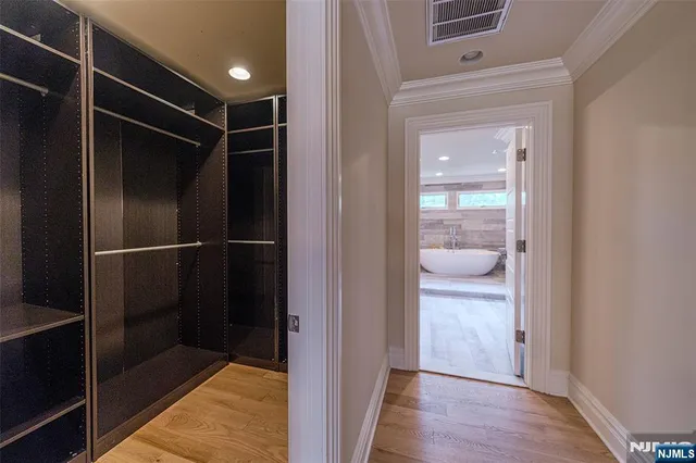 a view of walk in closet with wooden floor and fan