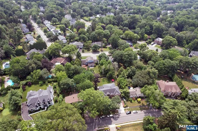 an aerial view of a houses with a yard and lake view