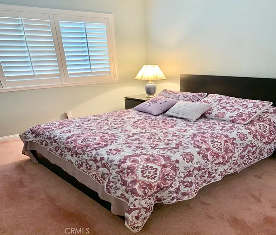 a bed sitting in a bedroom next to a window