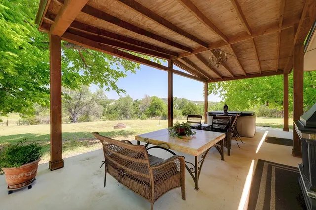 a view of a patio with chairs and floor to ceiling window