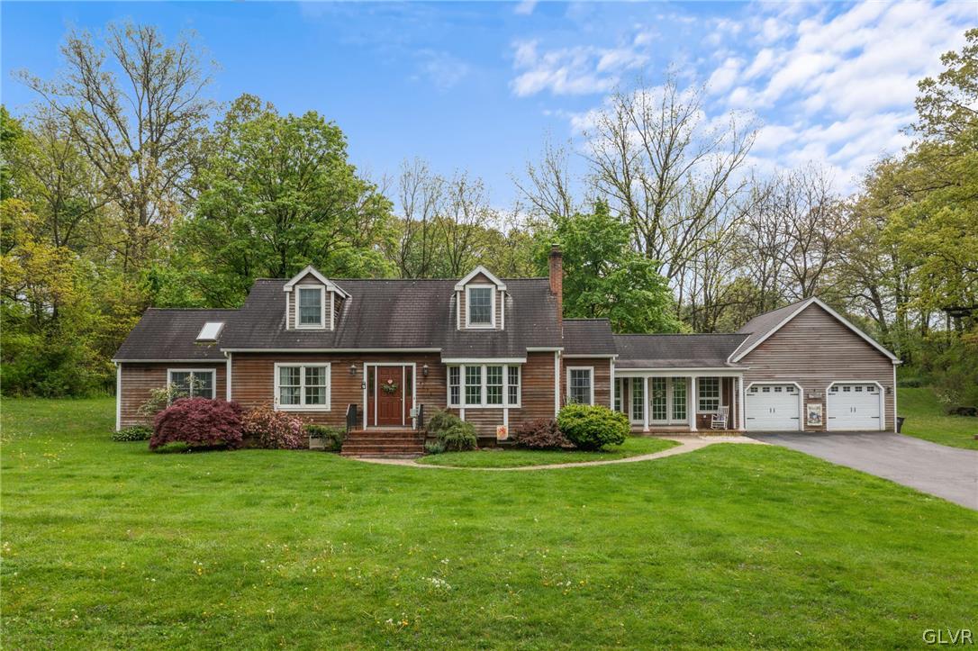 4236 Huckleberry Road Allentown, PA 18104 - Photo 1 of 39 a front view of a house with a garden and trees