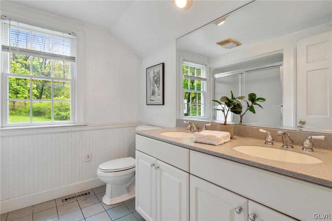 4236 Huckleberry Road Allentown, PA 18104 - Photo 36 of 39 a bathroom with a granite countertop toilet a sink and a window
