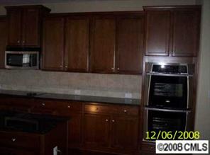 85542 Arrington Road Lancaster, SC 29720 - Photo 2 of 8 a kitchen with stainless steel appliances granite countertop wooden cabinets and a stove top oven