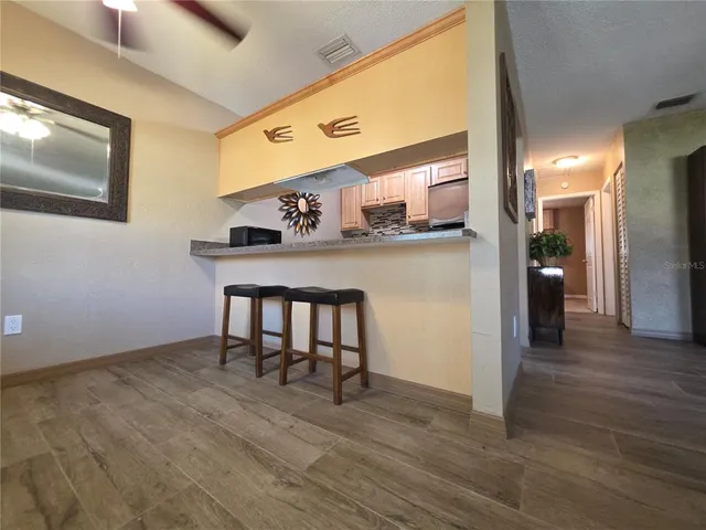 a view of a hallway with wooden floor and windows