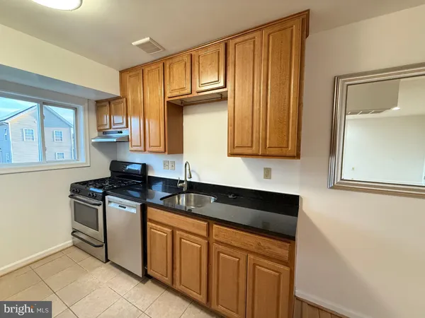 a kitchen with stainless steel appliances granite countertop a sink stove and cabinets