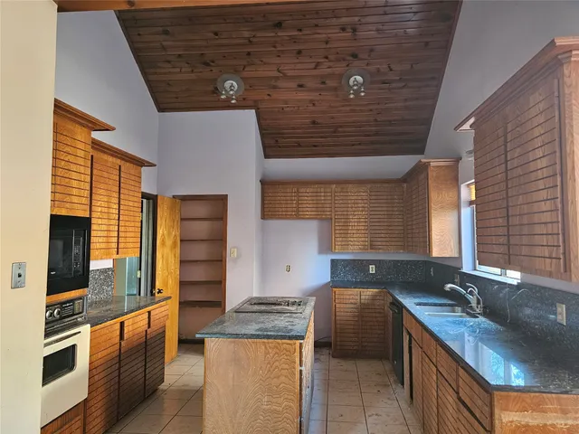 a kitchen with granite countertop a sink and a stove