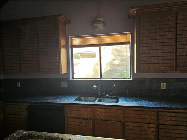 a kitchen with a sink a window and cabinets