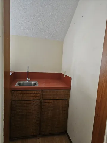 a room with a sink and wooden floor