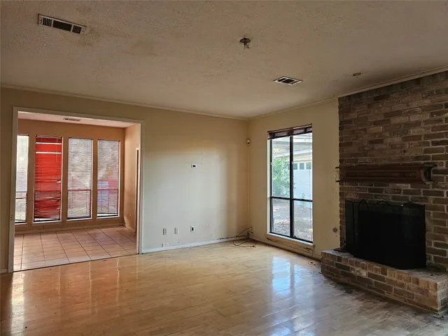 a view of an empty room with a fireplace and a window