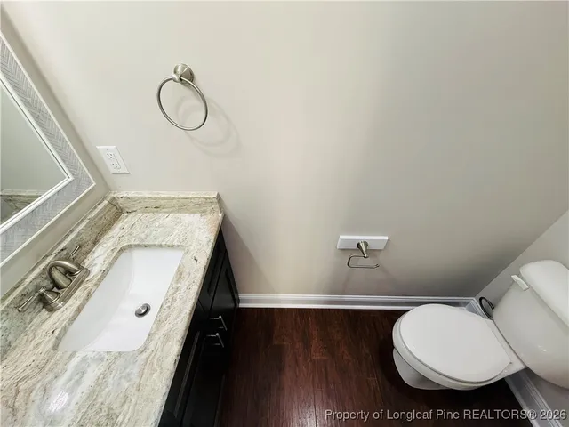 a bathroom with a granite countertop sink toilet and a mirror