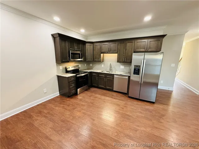 a kitchen with stainless steel appliances granite countertop a sink and a refrigerator