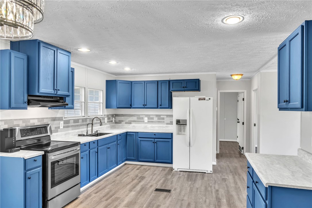 119 Ray Drive Pickens, SC 29671 - Photo 9 of 27 This renovated kitchen features bright blue cabinetry and sleek appliances, perfect for everyday living.
