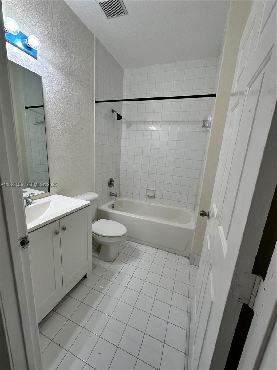 1529 Southeast 24th Court, Unit 233 Homestead, FL 33035 - Photo 12 of 35 a bathroom with a double vanity sink toilet and shower