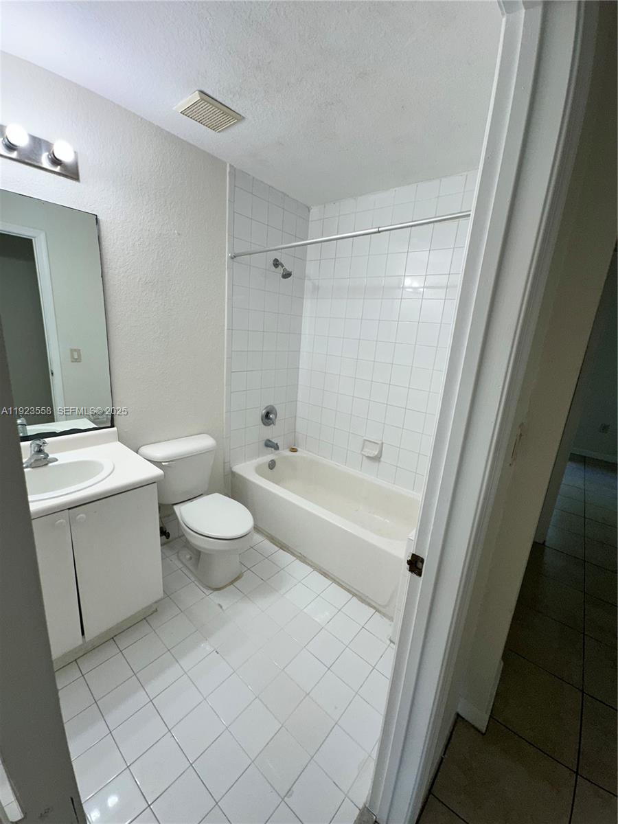 1529 Southeast 24th Court, Unit 233 Homestead, FL 33035 - Photo 14 of 35 a bathroom with a sink a toilet and shower