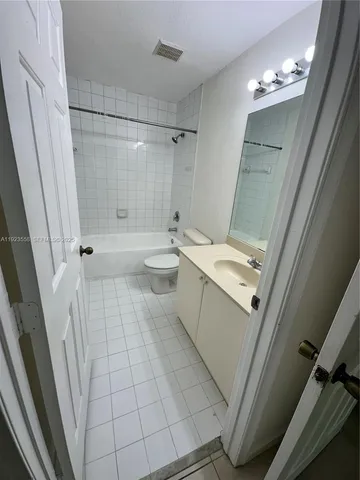 a bathroom with a sink a toilet a mirror and shower