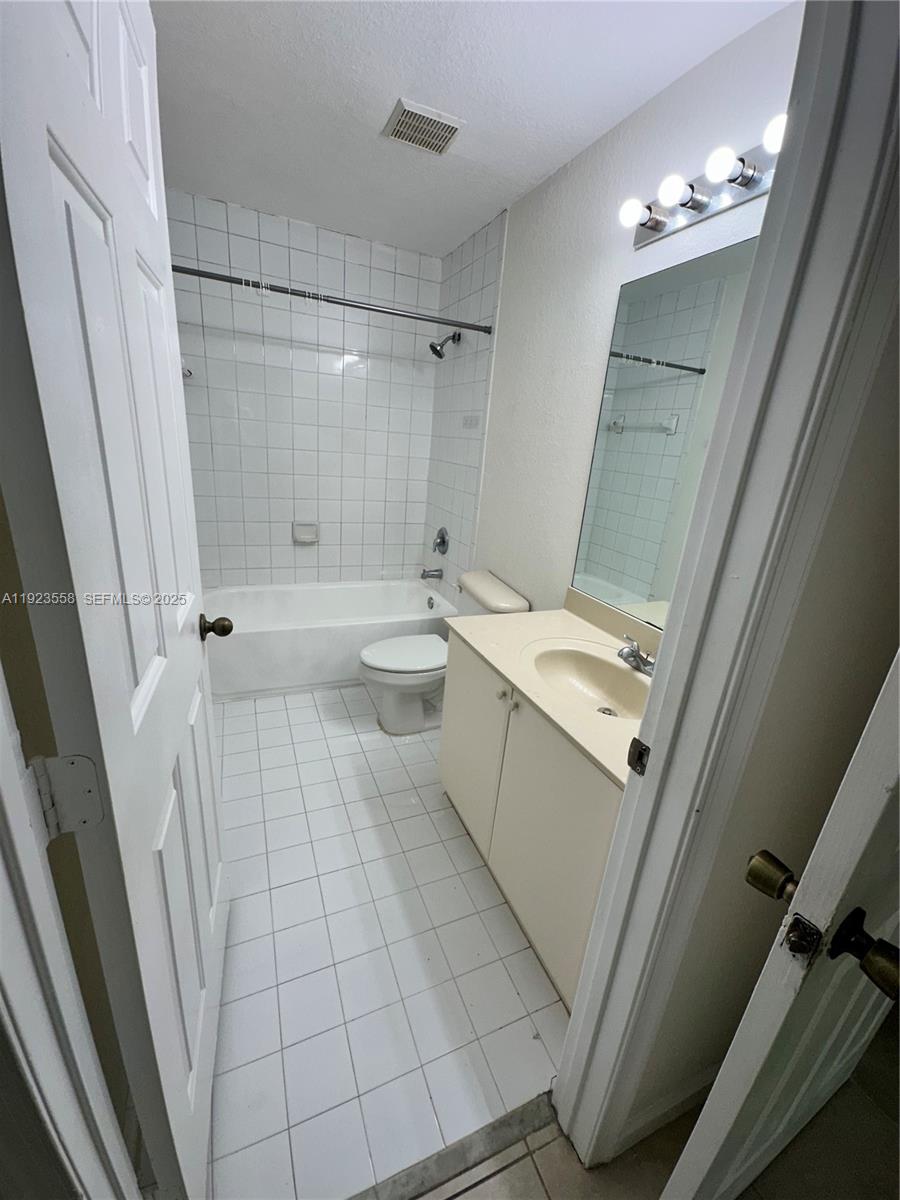 1529 Southeast 24th Court, Unit 233 Homestead, FL 33035 - Photo 15 of 35 a bathroom with a sink a toilet a mirror and shower