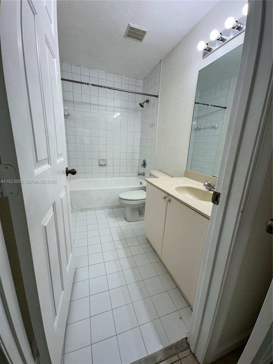 1529 Southeast 24th Court, Unit 233 Homestead, FL 33035 - Photo 19 of 35 a bathroom with a sink a toilet a mirror and shower