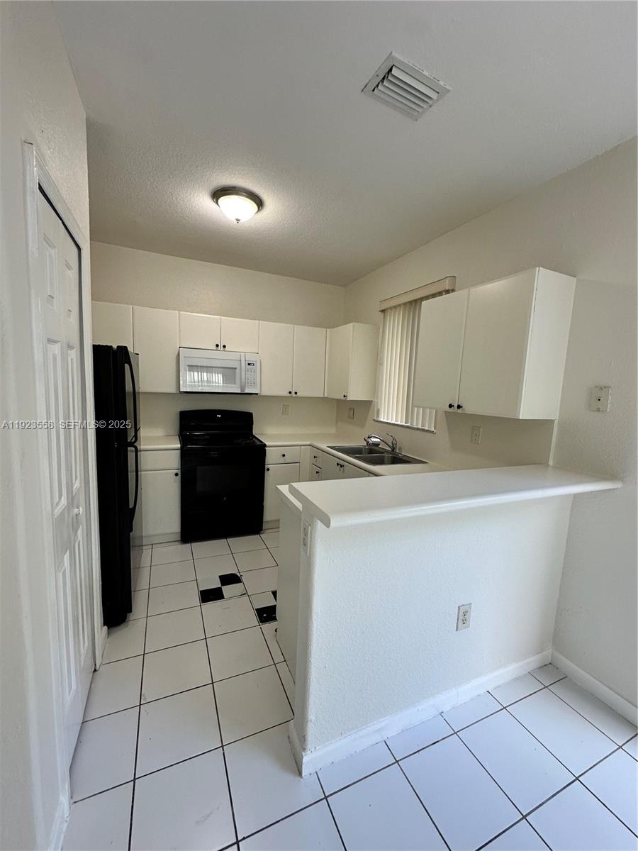 1529 Southeast 24th Court, Unit 233 Homestead, FL 33035 - Photo 7 of 35 a kitchen with stainless steel appliances granite countertop a refrigerator and a stove top oven