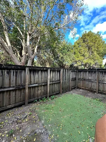 a view of a backyard with wooden fence