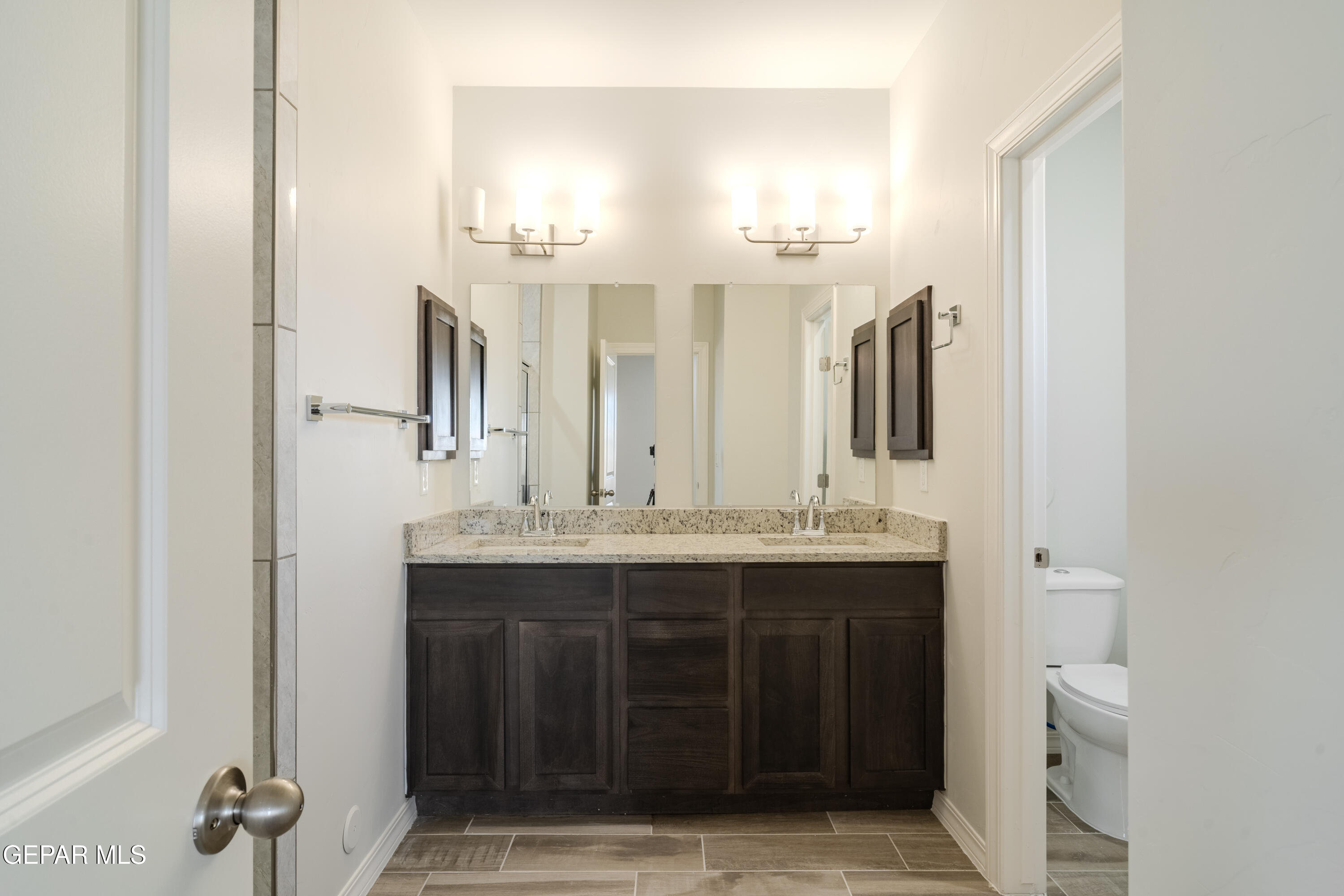 985 Barbara Avenue Socorro, TX 79927 - Photo 14 of 29 a bathroom with a double vanity sink and a mirror