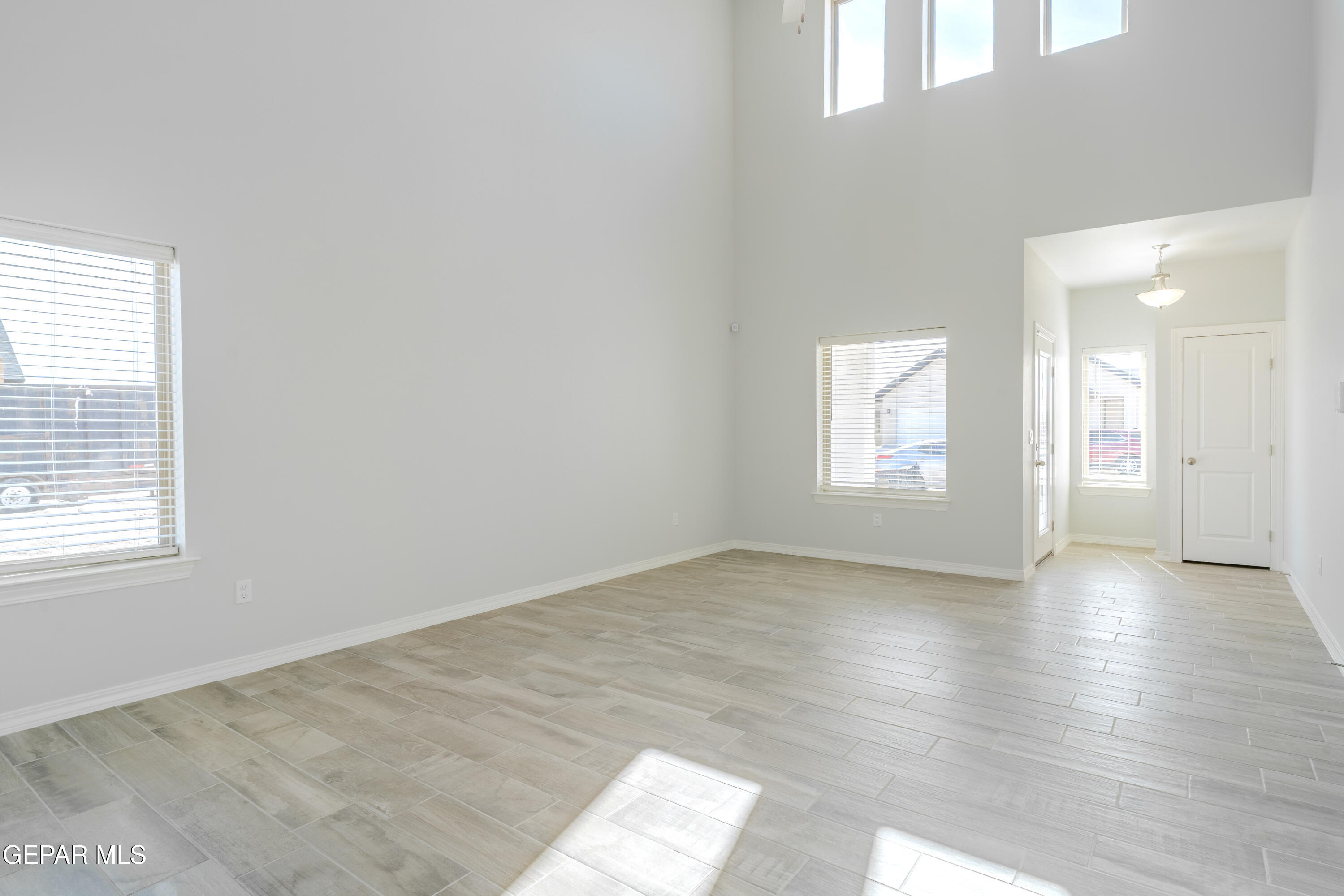 985 Barbara Avenue Socorro, TX 79927 - Photo 4 of 29 an empty room with wooden floor and windows