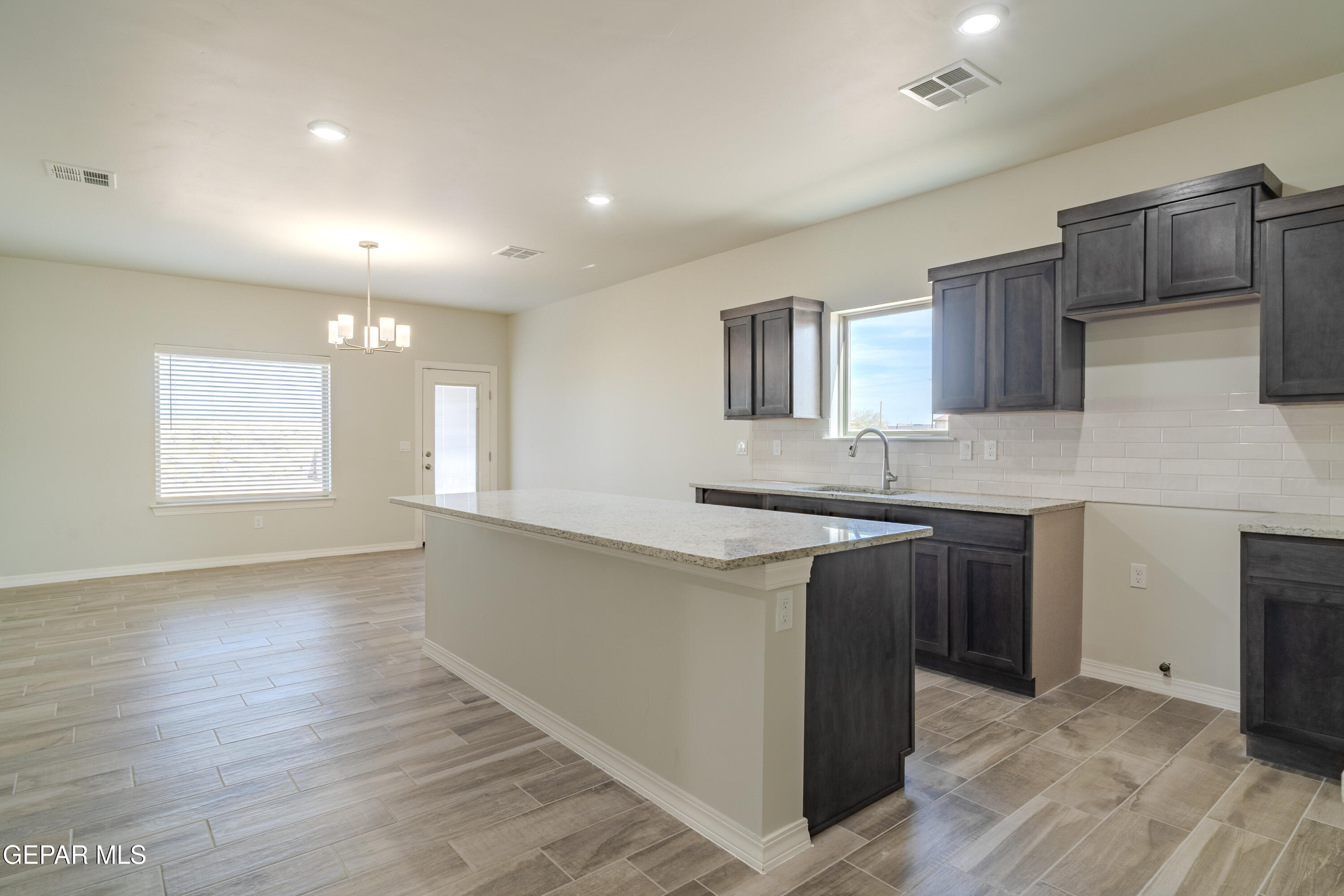 985 Barbara Avenue Socorro, TX 79927 - Photo 5 of 29 a kitchen with granite countertop wooden cabinets a sink and dishwasher