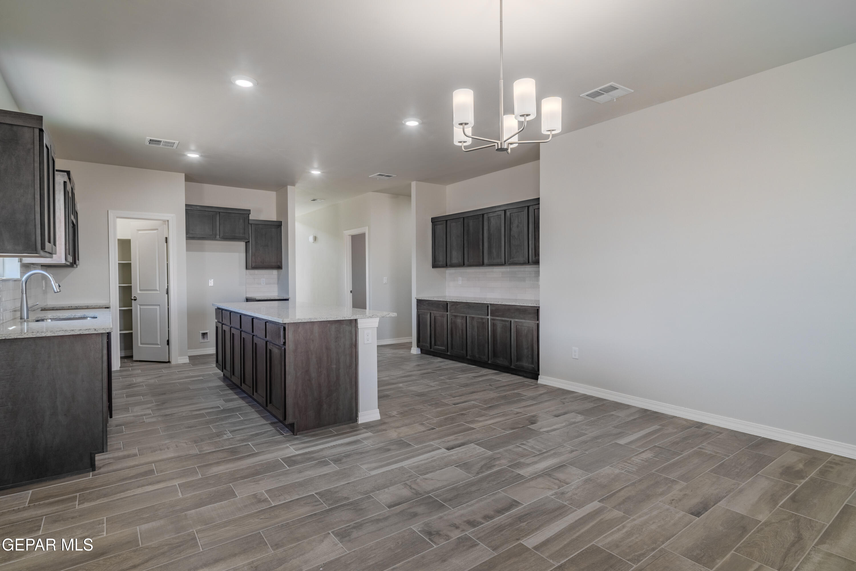 985 Barbara Avenue Socorro, TX 79927 - Photo 7 of 29 a large kitchen with kitchen island a island wooden cabinets and stainless steel appliances