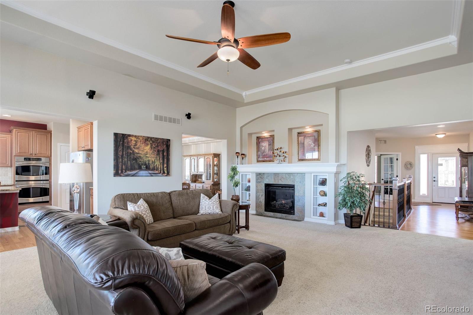 3441 Antelope Ridge Trail Parker, CO 80138 - Photo 11 of 50 a living room with furniture a fireplace and a chandelier