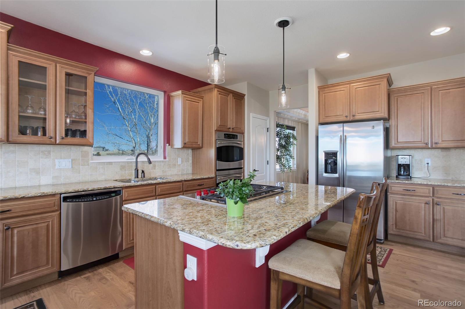 3441 Antelope Ridge Trail Parker, CO 80138 - Photo 15 of 50 a kitchen with granite countertop kitchen island stainless steel appliances a sink cabinets and living room view