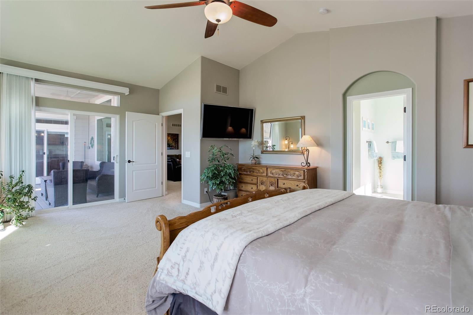 3441 Antelope Ridge Trail Parker, CO 80138 - Photo 25 of 50 a spacious bedroom with a bed and a flat screen tv