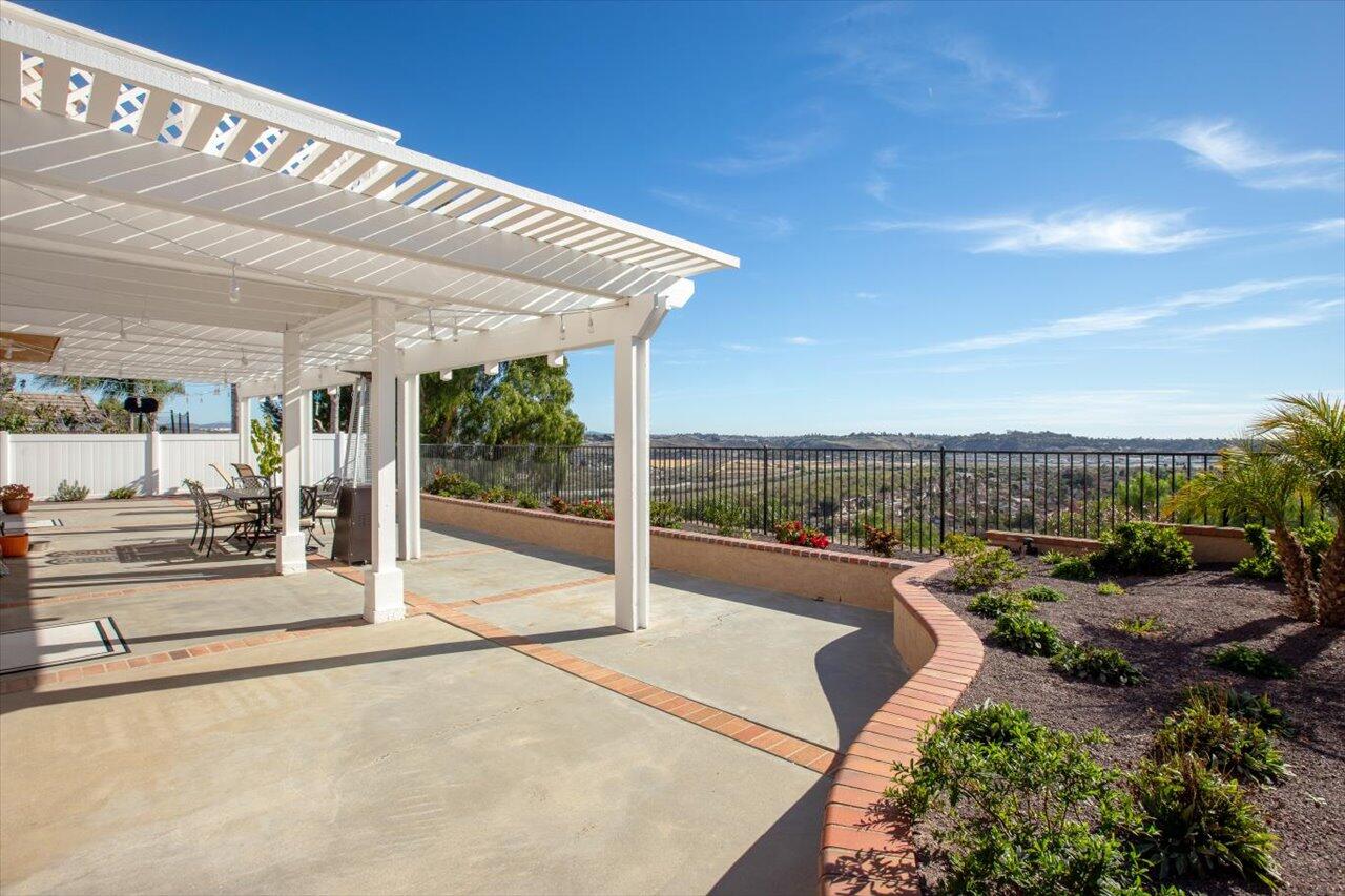 911 Rivertree Drive Oceanside, CA 92058 - Photo 28 of 43 a view of a patio with table and chairs under an umbrella