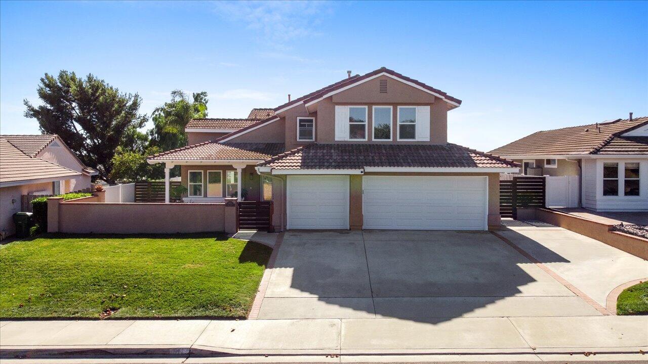 911 Rivertree Drive Oceanside, CA 92058 - Photo 4 of 43 a front view of a house with a yard and garage