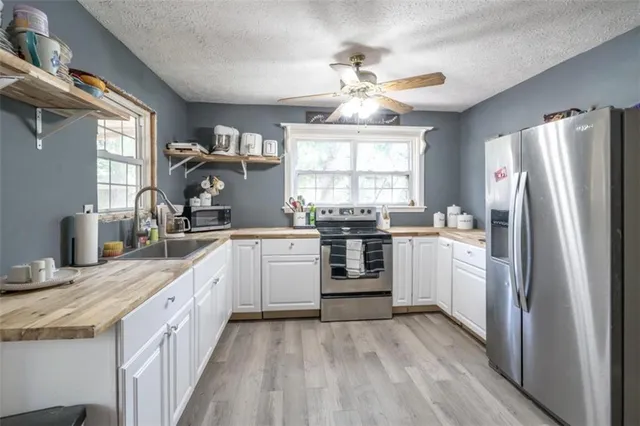 a kitchen with a sink window and refrigerator