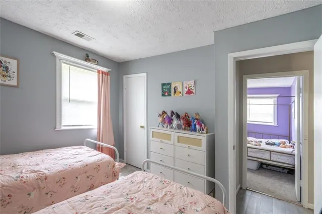 a bedroom with a bed dresser and a window