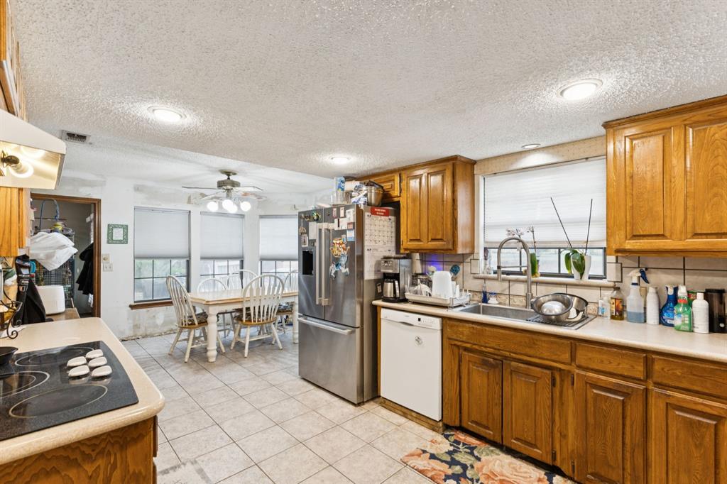 202 Blue Mound Road East Haslet, TX 76052 - Photo 14 of 31 a kitchen with stainless steel appliances granite countertop a stove top oven a sink dishwasher and cabinets with wooden floor