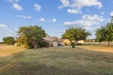 a front view of house with yard and trees around