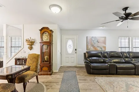 a living room with furniture a ceiling fan and a rug