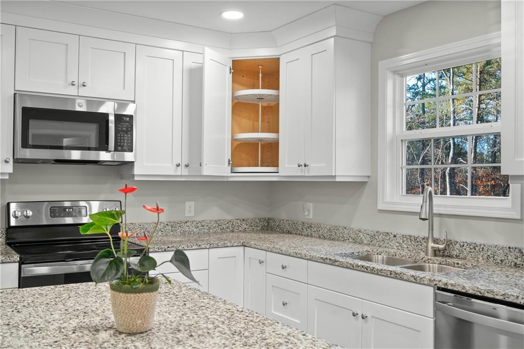2708 Quarles Road Rocky Face, GA 30740 - Photo 16 of 40 a kitchen with stainless steel appliances granite countertop a sink a microwave and cabinets