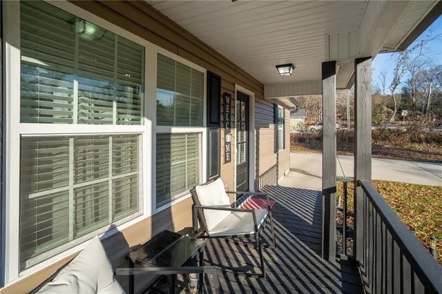 a view of a white house with a yard and sitting area