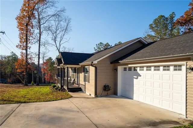a kitchen with stainless steel appliances granite countertop a dining table chairs refrigerator and sink