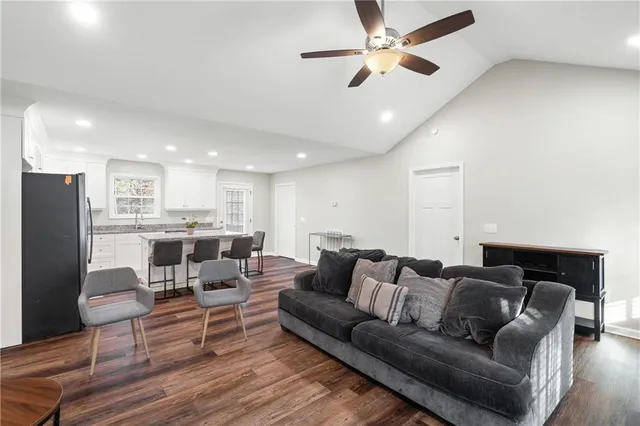 a kitchen with stainless steel appliances granite countertop a refrigerator a stove a sink a dining table and chairs