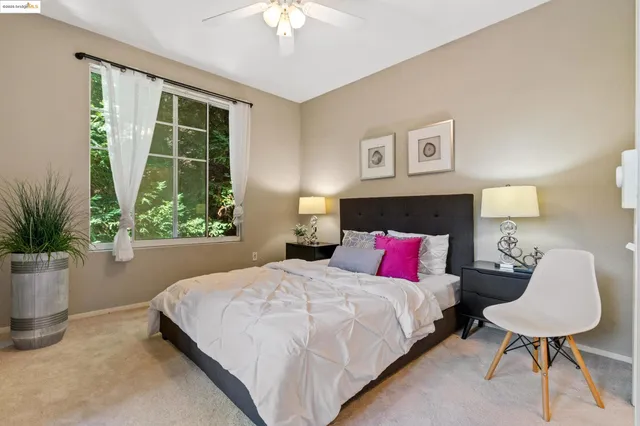 a bedroom with a large bed and a potted plant