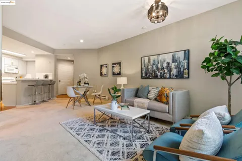 a living room with furniture a chandelier and a rug