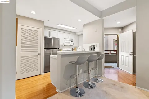 a kitchen with stainless steel appliances a refrigerator a sink dishwasher and a stove with wooden floor