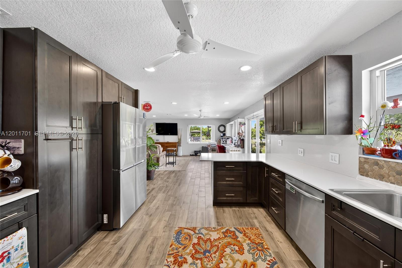 21175 Southwest 232nd Street Miami, FL 33170 - Photo 11 of 66 a large kitchen with a large center island wooden floor and stainless steel appliances