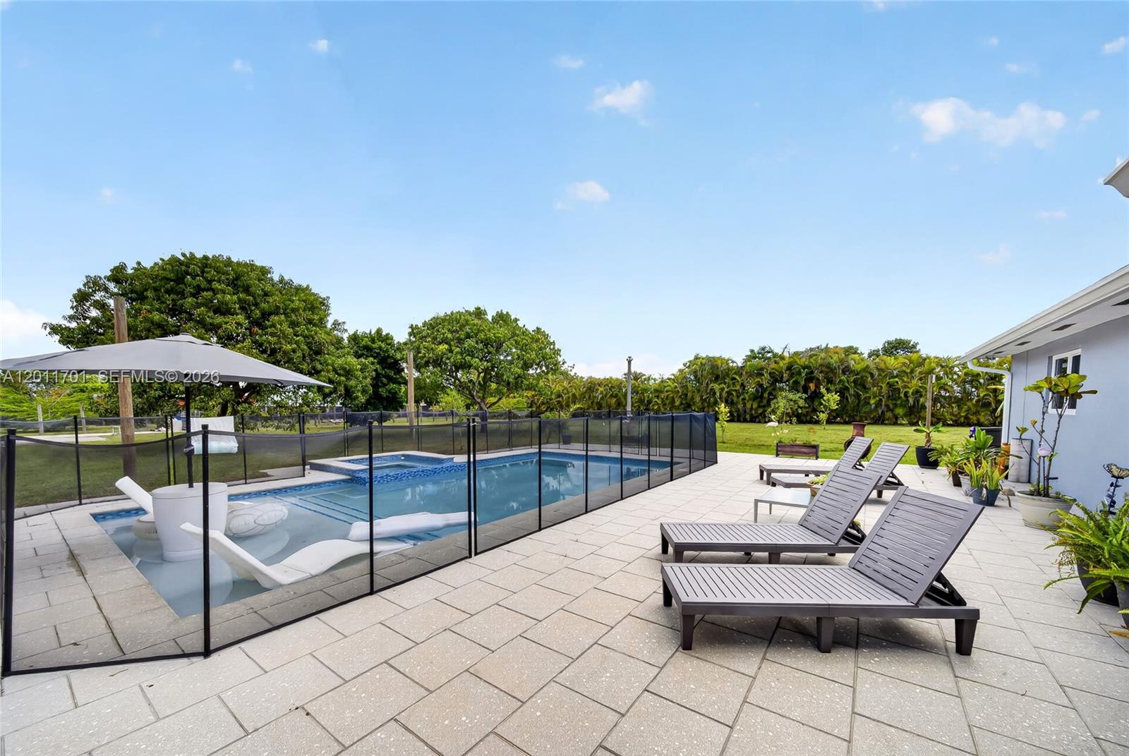 21175 Southwest 232nd Street Miami, FL 33170 - Photo 33 of 66 a view of a terrace with furniture and umbrella