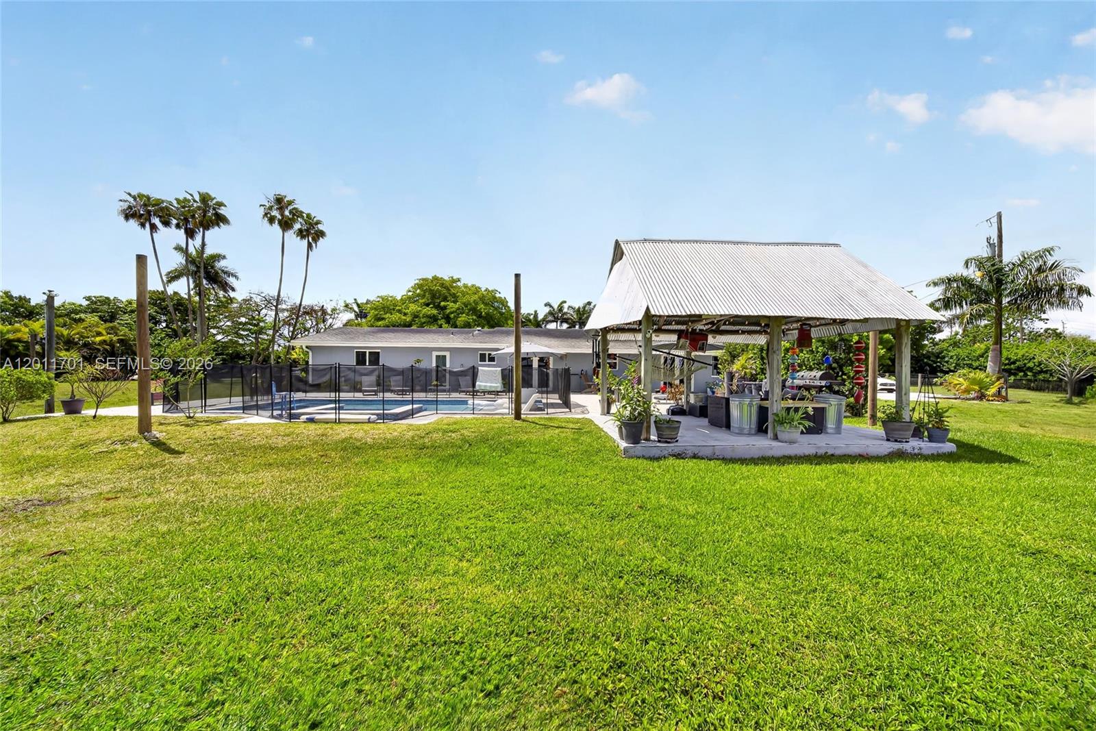 21175 Southwest 232nd Street Miami, FL 33170 - Photo 44 of 66 a view of swimming pool with table and chairs under an umbrella