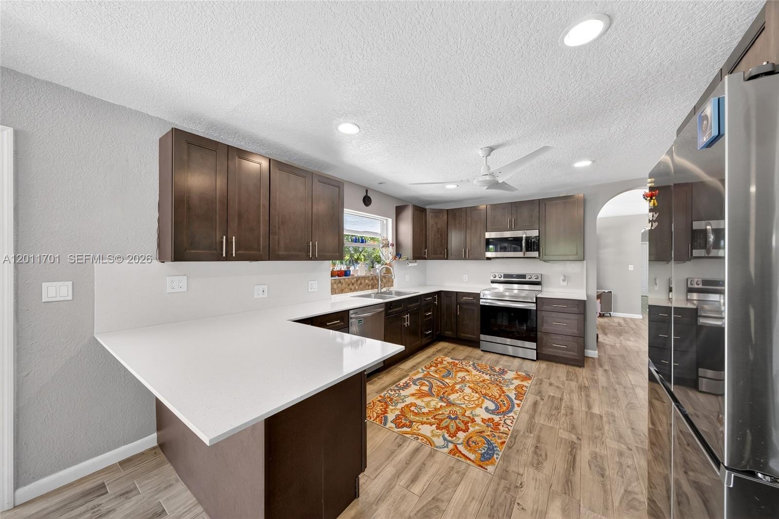 21175 Southwest 232nd Street Miami, FL 33170 - Photo 7 of 66 a kitchen with stainless steel appliances kitchen island granite countertop a refrigerator and a stove top oven