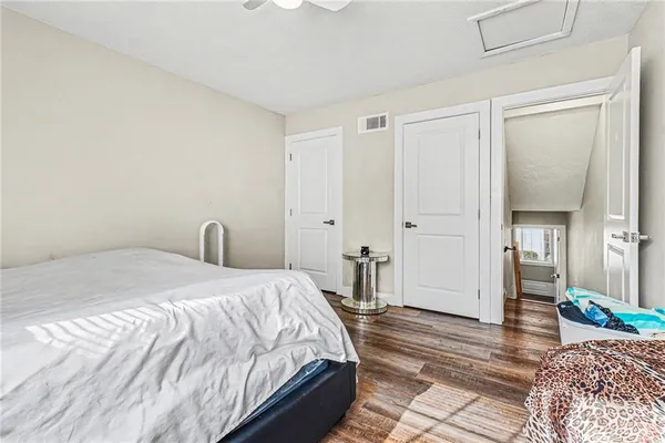 a bedroom with a bed and wooden floor