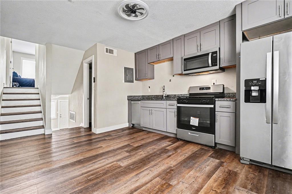405 Fairburn Road Southwest, Unit 231 Atlanta, GA 30331 - Photo 6 of 16 a kitchen with stainless steel appliances a stove top oven a refrigerator cabinets and a wooden floor